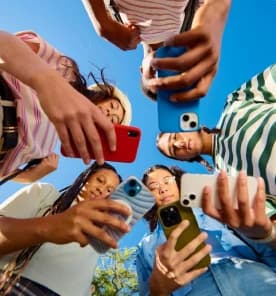 Young people looking down at their phones, seen from below